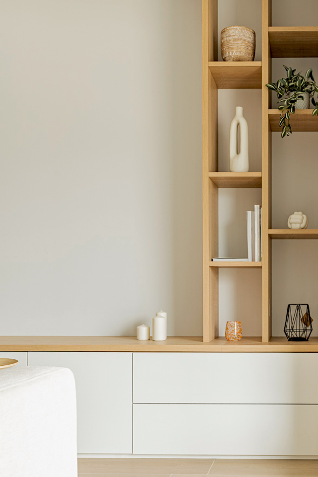 Mueble TV a medida combinando madera de roble y blanco . Co una zona baja para almacenamiento y una estantería vertical para libros y decoración.